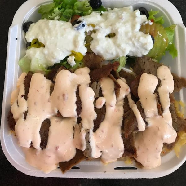 Arhiboo Shawarma's gyro plate with meat, pink sauce, and a side salad with white dressing.